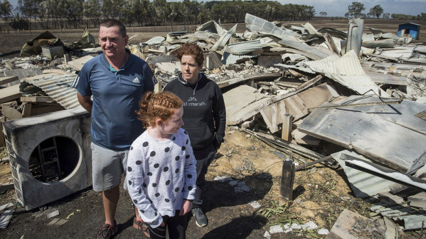 Phil and Maree Beasley with their 11-year-old daughter amid the wreckage of their Terang home.