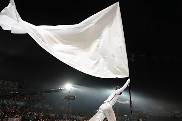 A performer waves a giant flag during the opening ceremony.