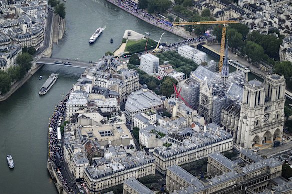 An aerial vote of the Notre-Dame as boats carrying Olympic athletes float along the Seine.