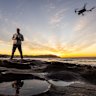Jason Iggledon flying his drone on the rocks at the southern end of Bondi Beach.