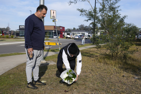 A couple place flowers at a roadblock near the scene of the crash.