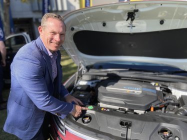 Renewables and Hydrogen Minister Mick de Brenni checks under the bonnet of a Hyundai NEXO.