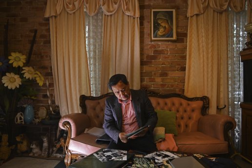 At his home in Oatley, Stephen Nguyen looks at photos from the night he was rescued by the HMAS Melbourne on June 21, 1981.