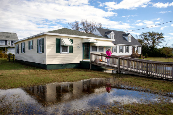 Bonnie Landon stands in front of her home amid her flooded lawn on Tangier Island in Virginia.