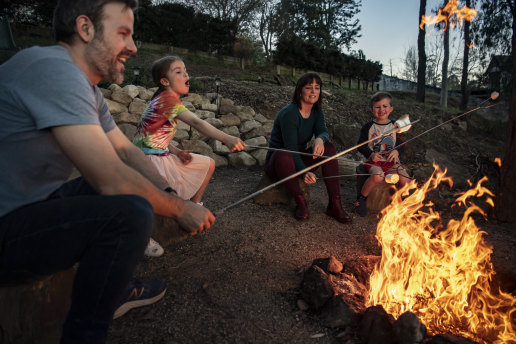 Matt Stanowski and Laura Fitzpatrick toast marshmallows with their two children Audrey, 7, and Michael, 5, in the fire pit at their home in Glenbrook. 