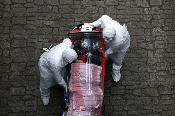 Medical staff move a patient infected with the coronavirus from an ambulance to a hospital in Seoul on Monday.