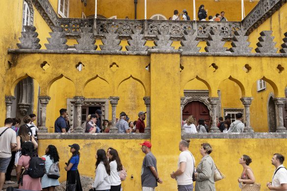 Tourists queue to visit the interior of the 19th century Pena Palace in Sintra, Portugal.