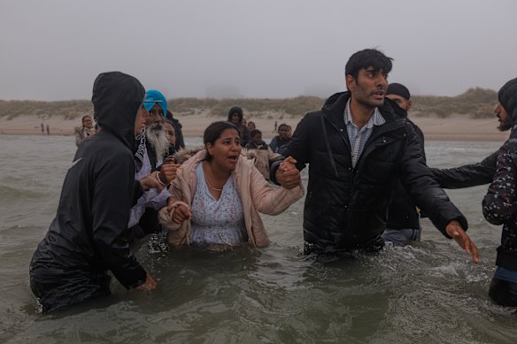 Families try to make their way to a small boat just off the shore in Gravelines this month. They were unsuccessful and made their way back to the beach to try another day.