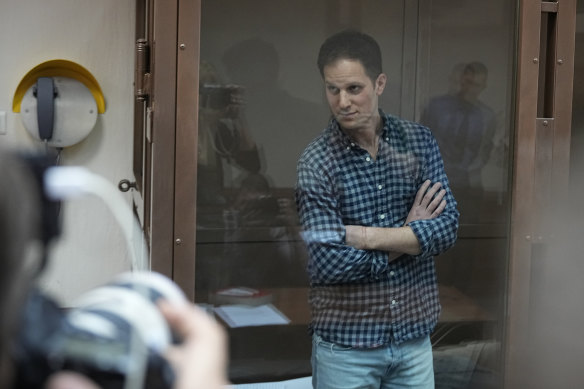 Wall Street Journal reporter Evan Gershkovich stands in a glass cage in a Moscow courtroom.