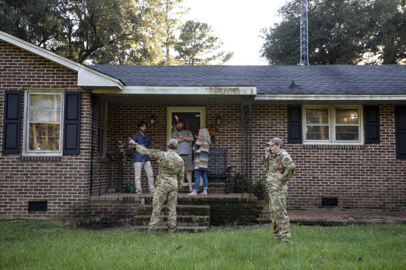 Airmen from Joint Base Charleston speak to a family living right next to the site of a crashed F-35 about the operation to recover the fighter jet in Williamsburg County, South Carolina, on September 18, 2023. 
