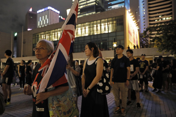 Alexandra Wong, 63 carries a Union flag as people queue up during a vigil to mourn the recent suicide of a woman due to the government's policy on the extradition bill in Hong Kong in July.