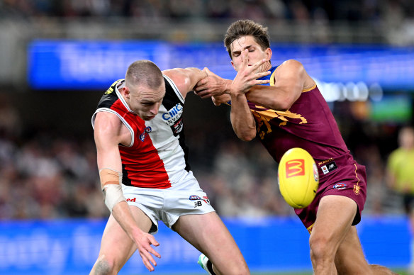 Callum Wilkie of the Saints and Zac Bailey of the Lions compete for the ball.