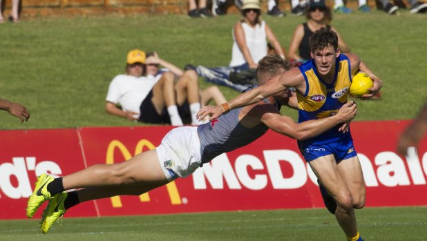 Fully committed: West Coast's Jack Redden fends off a flying tackle from Port's Ollie Wines.