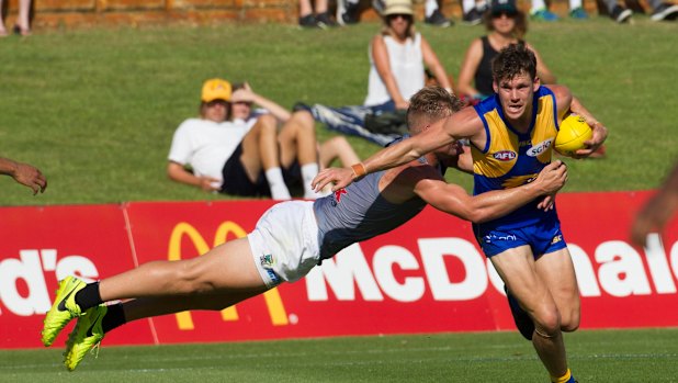 Fully committed: West Coast's Jack Redden fends off a flying tackle from Port's Ollie Wines.