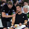 Thanasi Kokkinakis in the hands of a physio during his Adelaide International match against Sebastian Korda.