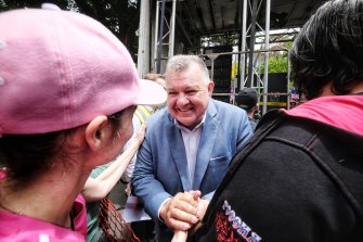 Former Liberal MP Craig Kelly shakes hands with a protester at the rally. 