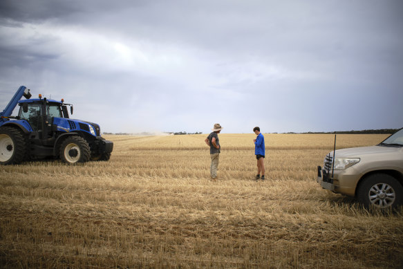 Grain farmer Mick Elford discusses the weather with chaser bin driver Ryder Morriss. 