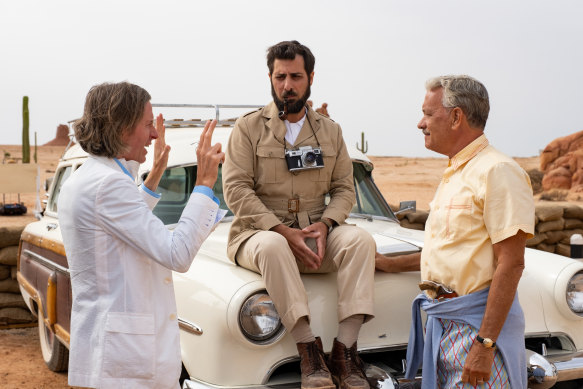 From left, Anderson speaks to actors Jason Schwartzman and Tom Hanks on set.