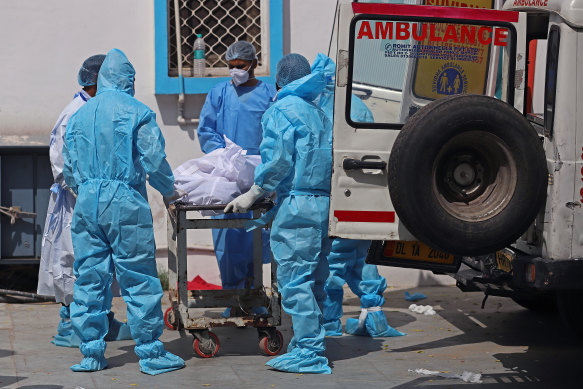 Health workers move the body of a COVID-19 victim at a mortuary in New Delhi on Wednesday.