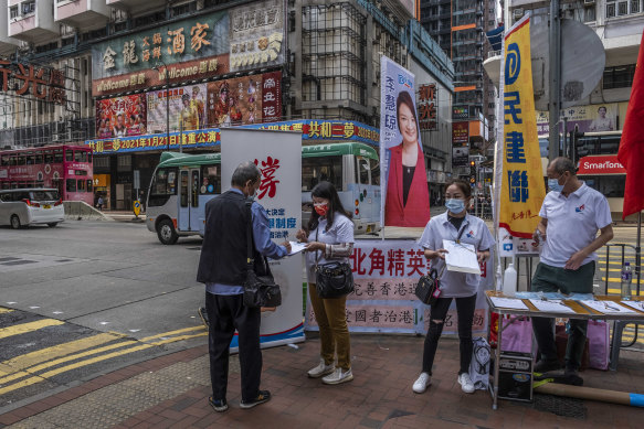 Pro-Bejing supporters campaign for a new election system in Hong Kong, March 11, 2021. Beijing is making it nearly impossible for the pro-democracy camp to win city elections. 