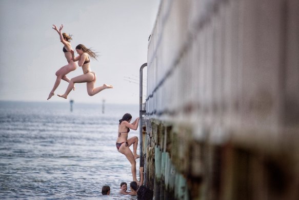 Teenagers jump off the pier in South Melbourne on Tuesday.
