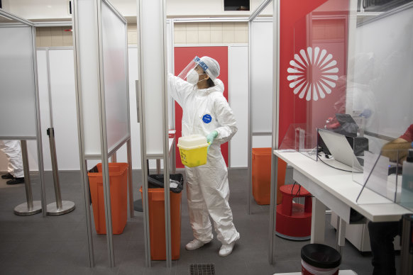 A medical worker cleans a COVID-19 testing site at at Berlin Brandenburg Airport this week.