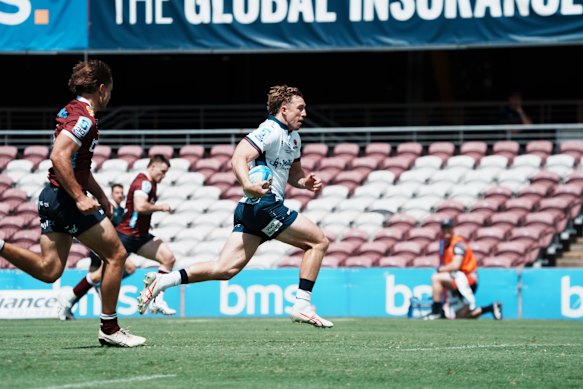 O ala dos Wallabies, Harry Potter, corre para marcar o primeiro try dos Waratahs em uma partida de pré-temporada contra os Reds em Brisbane.