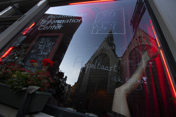 Oude Kerk, or Old Church, is reflected in the window of the Prostitution Information Centre as sex workers welcomed clients again in Amsterdam. 