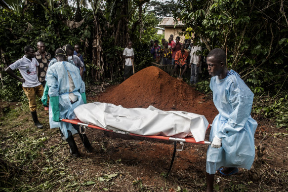 A Red Cross burial team prepares to bury the body of a woman suspected of dying of Ebola in Sierra Leone in 2014.