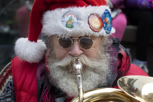 A music-minded Santa lookalike celebrates Christmas blow by tuba blow. 