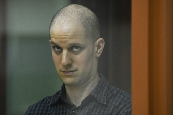 Wall Street Journal reporter Evan Gershkovich stands in a glass cage in a courtroom in Yekaterinburg, Russia.