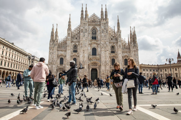 People walk through Duomo Square in front of the Dome Cathedral in Milan, Italy. The country is will now welcome visitors without a need for proof of vaccination.