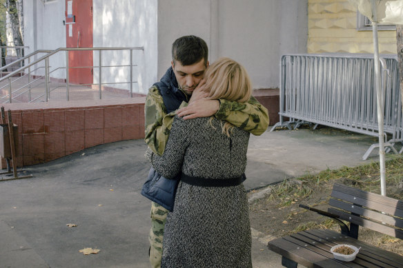 A Russian conscript hugs his partner as he bids her goodbye at a recruiting office in Moscow.