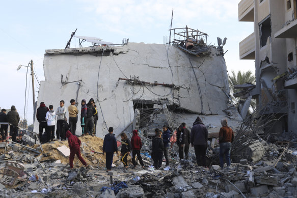 Palestinians look at the destruction after an Israeli strike on a residential building in Rafah, Gaza.