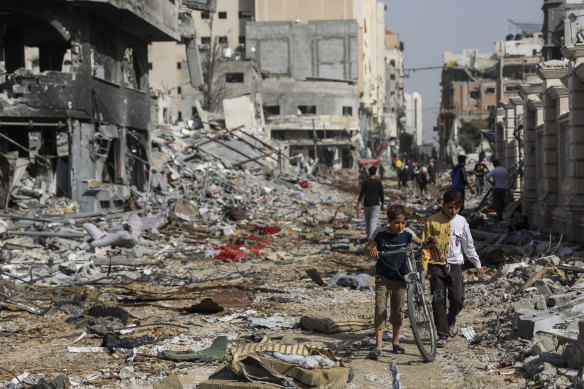Palestinians walk through destruction in Gaza City on Friday as the temporary truce took effect.