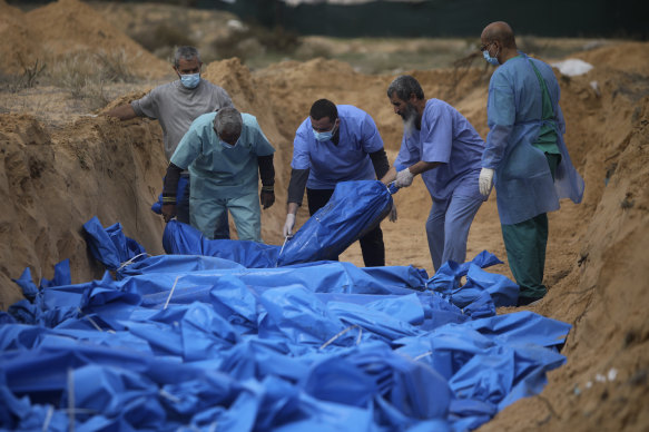 Palestinians bury bodies in a mass grave in the town of Khan Younis, in the southern Gaza Strip.