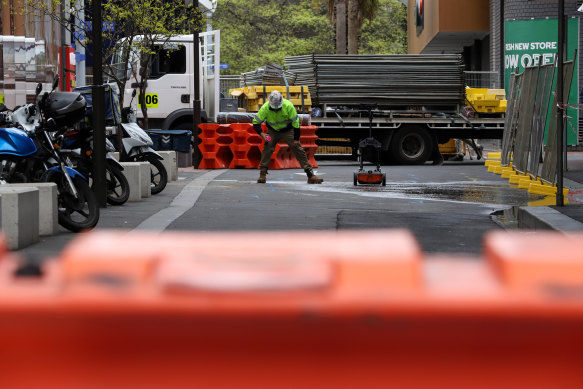 A worker marks the damages done by the earthquake near Prahran Square.