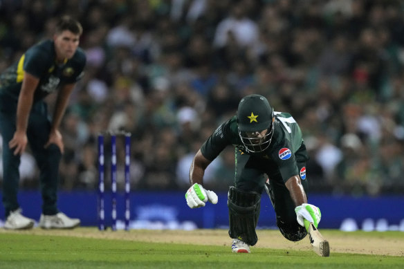 Pakistan’s Usman Khan dives to reach his crease earlier