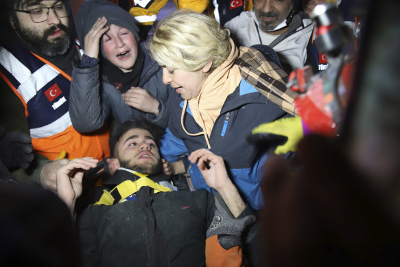 Rescuers and mother surround Adnan Mohammet Korkut after he was rescued in Gaziantep, southern Turkey, on Friday.