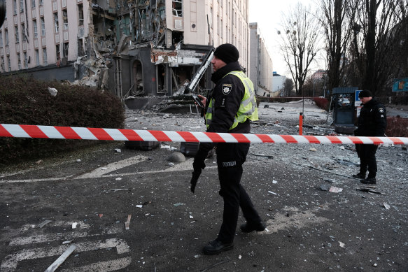Emergency personnel gather at the scene of a missile attack on New Year’s Eve, 2022 in Kyiv, Ukraine. 