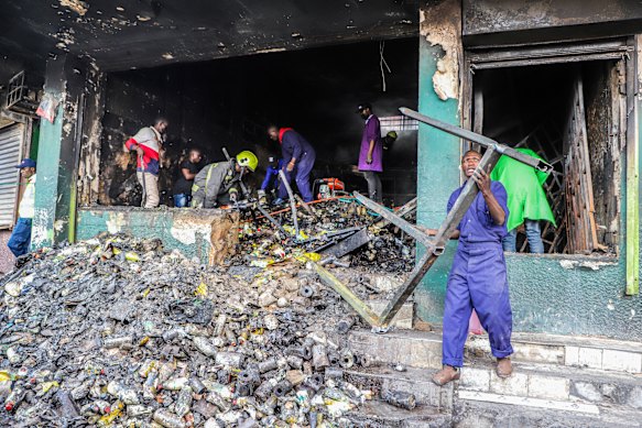 Business owners evaluate damage to their goods and vandalized stores. 