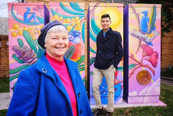 North Fitzroy resident Laura Brinson with Yarra Energy Foundation chief operating officer Tim Shue next to a new community battery, painted by artist Hayden Dewar 