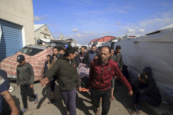 Palestyńczycy niosą ciało osoby zabitej w izraelskim zamachu bombowym na budynek centrum szkolenia zawodowego UNRWA, w którym przesiedleńcy pełnili funkcję schronienia w Khan Yunis.