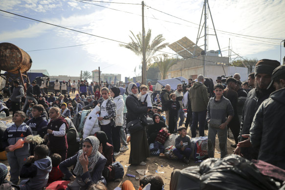 Displaced Palestinians gather with their belongings near a roadblock on the al Rashid Street, as they wait to return to their homes in the northern part of the Gaza Strip on Sunday.