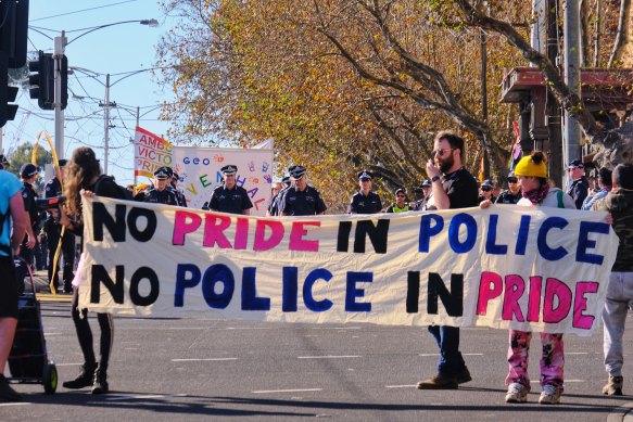 Protesters walked in front of police at the 2021 Pride March in St Kilda. The man with the walkie-talkie is a march marshal.