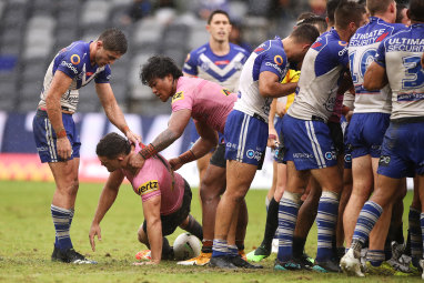 Nathan Cleary is helped to his feet after a careless high tackle by Dallin Watene-Zelezniak of the Bulldogs.