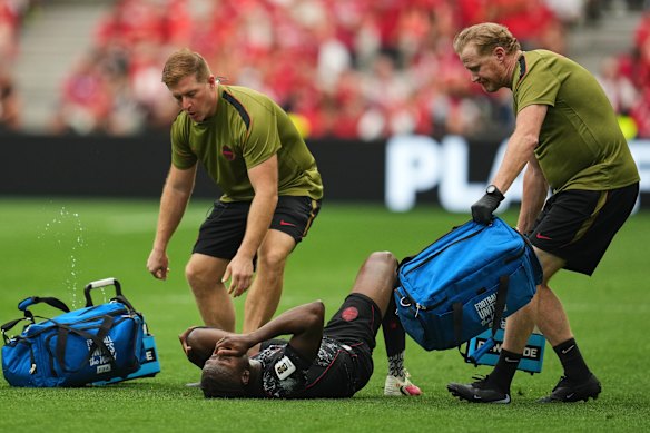 Canada’s Ismael Kone receives medical attention after a foul.