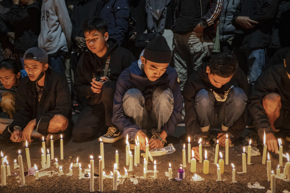 Arema football club supporters light candles during as they pray for the victims on October 02, 2022 in Malang, Indonesia.