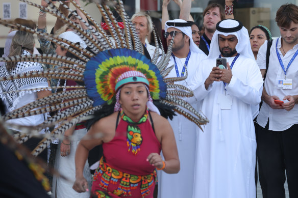 COP28 participants look on on Sunday as dancers of the Mexica Indigenous people of Mexico perform to honour ancestors missing or murdered through environmental exploitation.