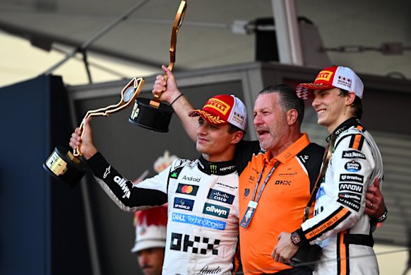 McLaren CEO Zak Brown (centre) with world champion Lando Norris (left) and Oscar Piastri.
